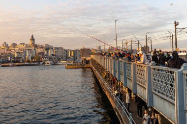İstanbul, Türkiye, 13 Nisan 2025, Galata Köprüsü 'nde balık tutan insanlar. İstanbul, Türkiye 'de Sokak Gıda Tedarikçileri, Balıkçılar ve Galata Kulesi Manzaralı Galata Köprüsü.