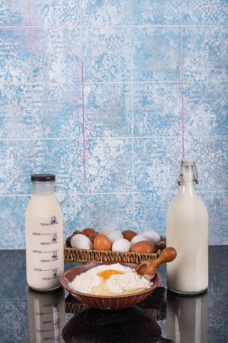 Süt unu Yumurta Mutfağı Konsepti. Kırsal mutfakta kek pişirmek - hamur tarifi malzemeleri (yumurta, un, süt, tereyağı, şeker) ve yukarıdaki eski ahşap masa üzerinde merdane. 