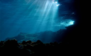 Artistic underwater photography of rays of sunlight over a reef