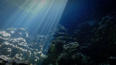 Artistic underwater photography of rays of sunlight inside a cave