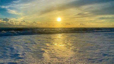 Manzara ve doğa manzarası. Okyanusun üzerinde bir günbatımı fotoğrafı. Altın turuncu ve sarı renklerle..