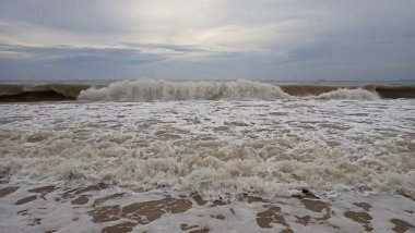 Tropikal bir adada okyanustan gelen vahşi dalgalar ve köpükler..