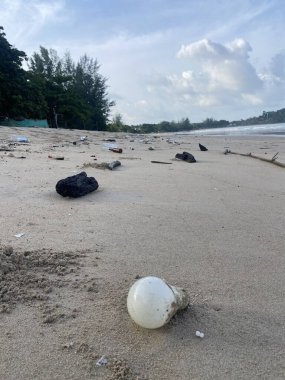 Tayland 'da bir plajda plastik çöp. Plastik çöpler ve tropik bir sahilde denizden gelen kirlilik. Okyanustan gelen bir sürü çöp ve plastik alçak mevsimde tropik bir adadan geliyor.