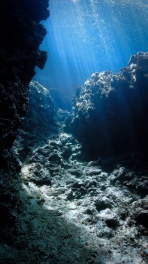 Mağaradaki güneş ışınlarının sualtı fotoğrafı. Tüplü dalıştan.