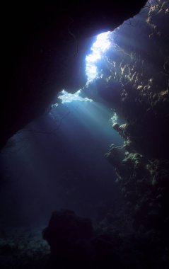 Işık katedralleri. Mağaradaki sihirli güneş ışınlarının sanatsal sualtı fotoğrafı. Tüplü dalıştan.