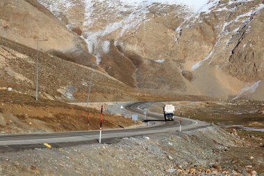Dik dağlar arasındaki sonbahar manzarasında bir otoyol manzarası.