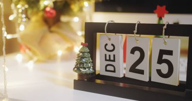 25 DEC noel günü Minimal takvim ve bayram xmas ışığı ile mutlu noeller metni ve geceleri oturma odasında Santa dall Bokeh ışıkları