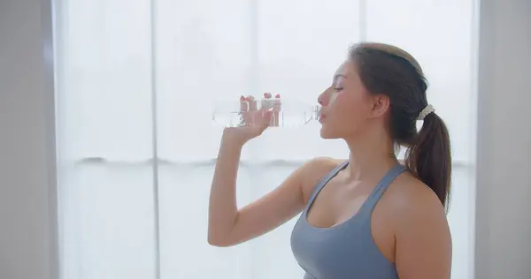 Evde yoga antrenmanı yaparken, spor giyinen, spor giyinen ya da ruhsal sağlığını koruyan mutlu, genç bir sporcu kadın. Denge, farkındalık ve sağlık.