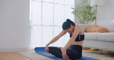 Güzel genç bir kadın barış için meditasyon yogası yapıyor esneme egzersizleri, fitness ya da ruhsal sağlık yapıyor. Denge, farkındalık ve sağIık ve evde dinlenme, nefes alma ve zihinsel eğitim.