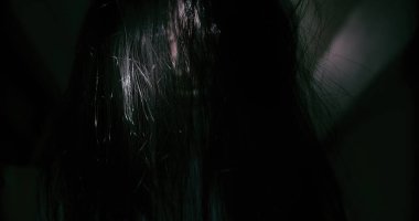 Esrarengiz bir korku sahnesi Asyalı bir hayalet kadının korkunç gözleri yüzünü kaplayan tüyler gecenin karanlığında karanlık bir sahne filmiyle terkedilmiş eve bakıyor, Cadılar Bayramı festivali