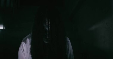 Esrarengiz bir korku sahnesi Asyalı bir hayalet kadının korkunç gözleri yüzünü kaplayan tüyler gecenin karanlığında karanlık bir sahne filmiyle terkedilmiş eve bakıyor, Cadılar Bayramı festivali