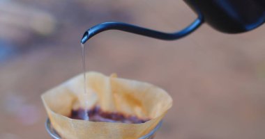 Kahve fincanına bir kahve filtresi dökülüyor.