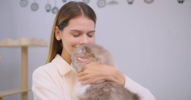 Şirin, güzel, güzel bir kadının portresi sevimli, tüylü bir kediye sarılıyor, evcil hayvanlarla insanlar arasındaki ilişkiyi anlatıyor. Evcil hayvan sahibinin kollarındaki tüylü kedi..