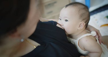Kapalı portre mutluluğu Asyalı aile çocuğu anne, kadın anne, bebek emzirici tatlı kız, evde annelik çocukluğu çocuğu sevgi ile bakılıyor.