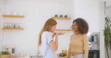 Birlikte eğlenen iki mutlu kadın, neşeli bir anı paylaşıyor. Igbtq 'ın parlak, modern bir mutfağında, eşcinsel ilişki kavramının tadını çıkarırken.