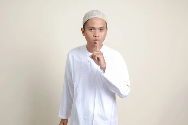 有魅力的亚洲穆斯林男子穿着白衬衫的画像 窃窃私语恶语相向 直言不讳地说出秘密谣言 灰色背景上的孤立图像 — 图库照片