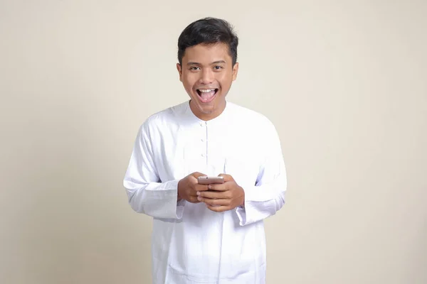 Portrét Atraktivního Asijského Muslima Bílé Košili Držícího Mobilní Telefon Úsměvem — Stock fotografie