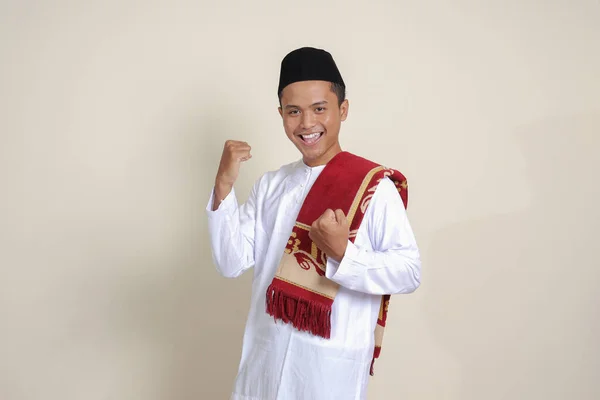 亚洲有魅力的穆斯林男子 身穿白衬衫 举起拳头 庆祝胜利 灰色背景上的孤立图像 — 图库照片