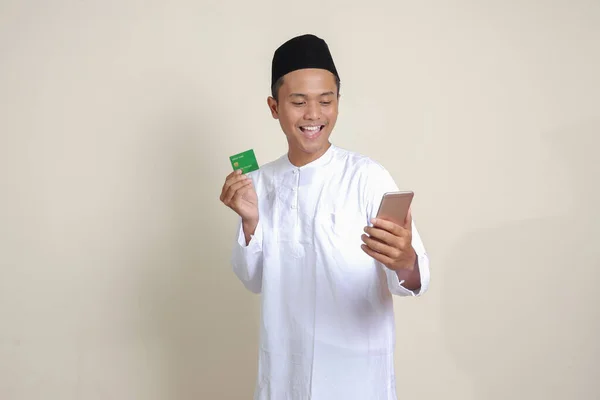 셔츠를 전화를 카드를 제시하는 매력적 아시아 남성의 초상화 배경의 고립된 — 스톡 사진