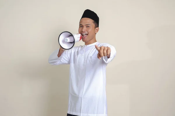 有魅力的亚洲穆斯林男子的画像 穿着白衬衫 头戴小帽 用扩音器大声说话 促销产品 广告概念 灰色背景上的孤立图像 — 图库照片