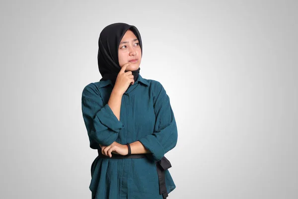 混乱したアジアのイスラム教徒の女性の肖像画ヒジャーブは白い背景に立って あごに手で質問を検索し 考えて — ストック写真