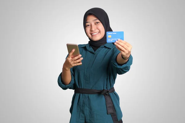 带头巾的快乐的亚洲穆斯林妇女的画像 手持手机时显示信用卡 金融和储蓄概念 白色背景上的孤立图像 — 图库照片