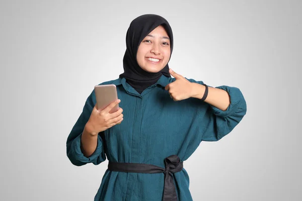 Heyecanlı Asyalı Müslüman Kadının Portresi Cep Telefonu Tutarken Başparmağıyla Işaret — Stok fotoğraf