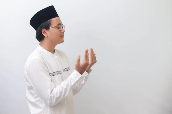 年轻的千年亚洲穆斯林男子的画像 他举起双手 诚挚地祈祷 白色背景上的孤立图像 — 图库照片