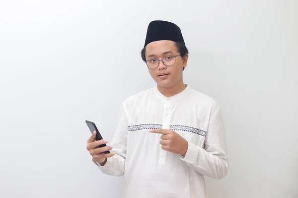 Portrét Mladého Vzrušeného Asijského Muslima Který Ukazuje Prstem Zatímco Používá — Stock fotografie