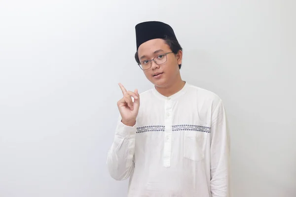 製品を示し 彼の手と指で指している若いアジアのイスラム教徒の男性の肖像画 白い背景に孤立したイメージ — ストック写真