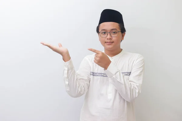Portrét Mladého Asijského Muslima Ukazujícího Produkt Ukazujícího Rukou Prstem Izolovaný — Stock fotografie