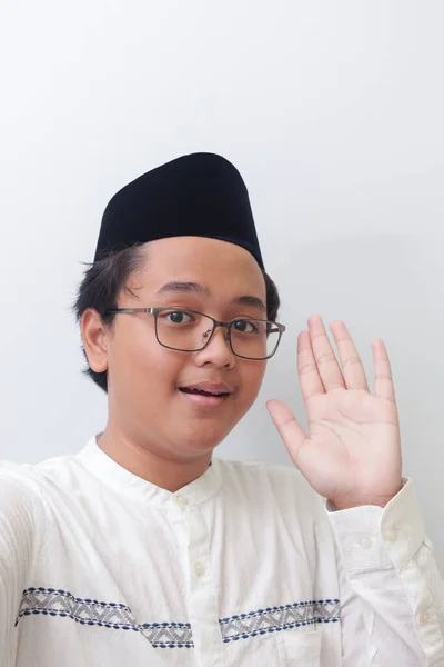 一个面带微笑的年轻的亚洲穆斯林男子为自己或自己拍照 打招呼和挥挥手的画像 屏幕捕获的电话 白色背景上的孤立图像 — 图库照片
