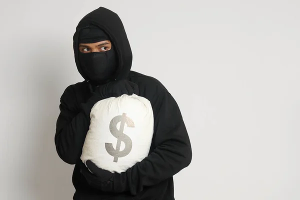 Siyah Kapüşonlu Maskeli Gizemli Hırsız Para Dolu Bir Çanta Taşıyor — Stok fotoğraf