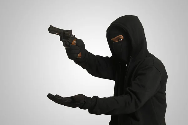 男の泥棒は強制的に銃で犠牲者のお金と貴重品を要求した — ストック写真