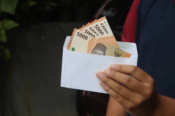 封筒に五千ルピア紙幣を挿入する男性の手の閉じる 財政と貯蓄の概念 — ストック写真
