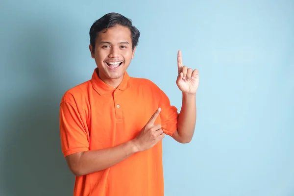 Pria Asia Yang Bersemangat Dengan Kemeja Oranye Tersenyum Dan Melihat — Stok Foto