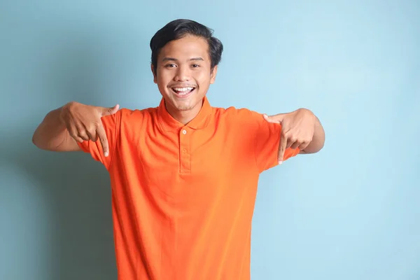 Pria Asia Yang Bersemangat Dengan Kemeja Oranye Tersenyum Dan Melihat — Stok Foto