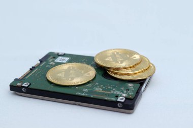 Sabit diskin üzerine yerleştirilmiş bir yığın bitcoin. Kripto para ticareti kavramı