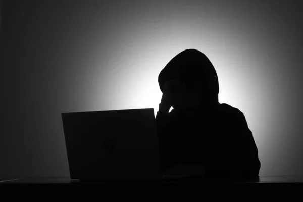 Karanlık Odada Siyah Kapüşonlu Dizüstü Bilgisayar Kullanan Kredi Kartı Tutan — Stok fotoğraf