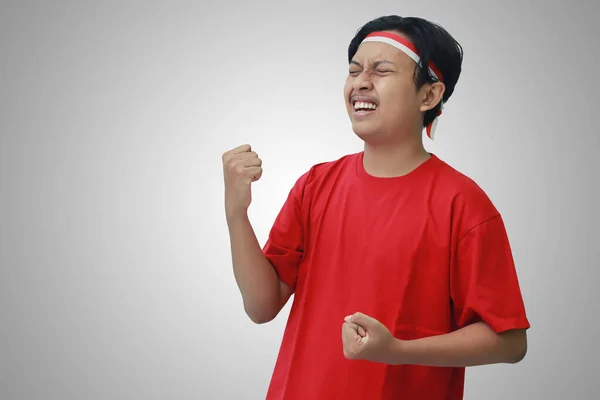 身穿T恤衫 头戴红白相间丝带的有魅力的亚洲男人的画像 举手表决 庆祝印尼独立日 灰色背景上的孤立图像 — 图库照片