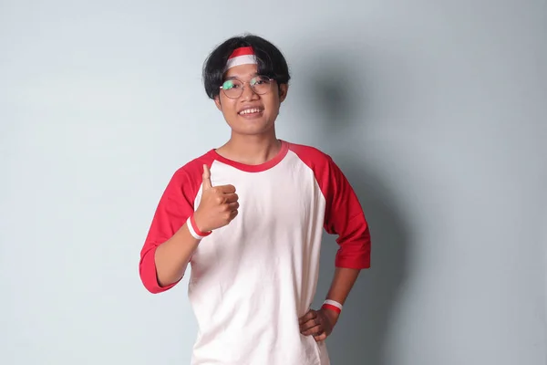 머리에 빨간색과 손가락으로 제스처를 보여주는 티셔츠에 매력적인 아시아 사람의 초상화 — 스톡 사진