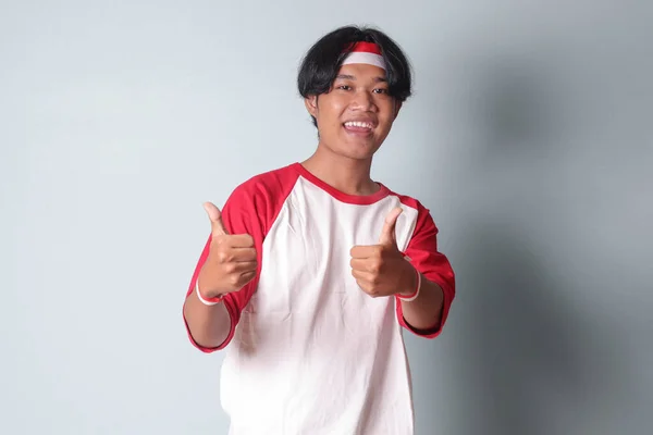 Portrét Atraktivního Asiata Tričku Červenou Bílou Stuhou Hlavě Ukazující Dobré — Stock fotografie