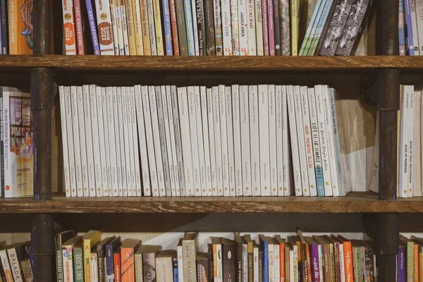 Industrial Dark Wooden Bookshelves Filled Social Fiction Self Improvement Biography — Stock Photo, Image