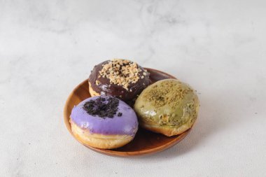 Tahta tabakta servis edilen farklı aromalı lezzetli çörekler. Beyaz arkaplanda izole edilmiş resim