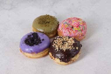 Masada farklı tatlar bulunan lezzetli çörekler. Beyaz arkaplanda izole edilmiş resim