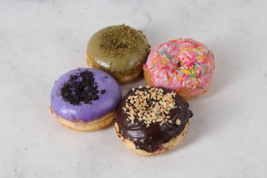 Masada farklı tatlar bulunan lezzetli çörekler. Beyaz arkaplanda izole edilmiş resim