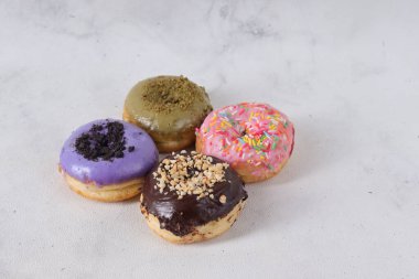 Masada farklı tatlar bulunan lezzetli çörekler. Beyaz arkaplanda izole edilmiş resim