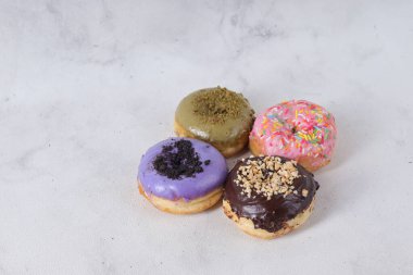 Masada farklı tatlar bulunan lezzetli çörekler. Beyaz arkaplanda izole edilmiş resim