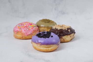 Masada farklı tatlar bulunan lezzetli çörekler. Beyaz arkaplanda izole edilmiş resim