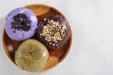 Tahta tabakta servis edilen farklı tatlara sahip lezzetli çöreklerin düz manzarası. Beyaz arkaplanda izole edilmiş resim